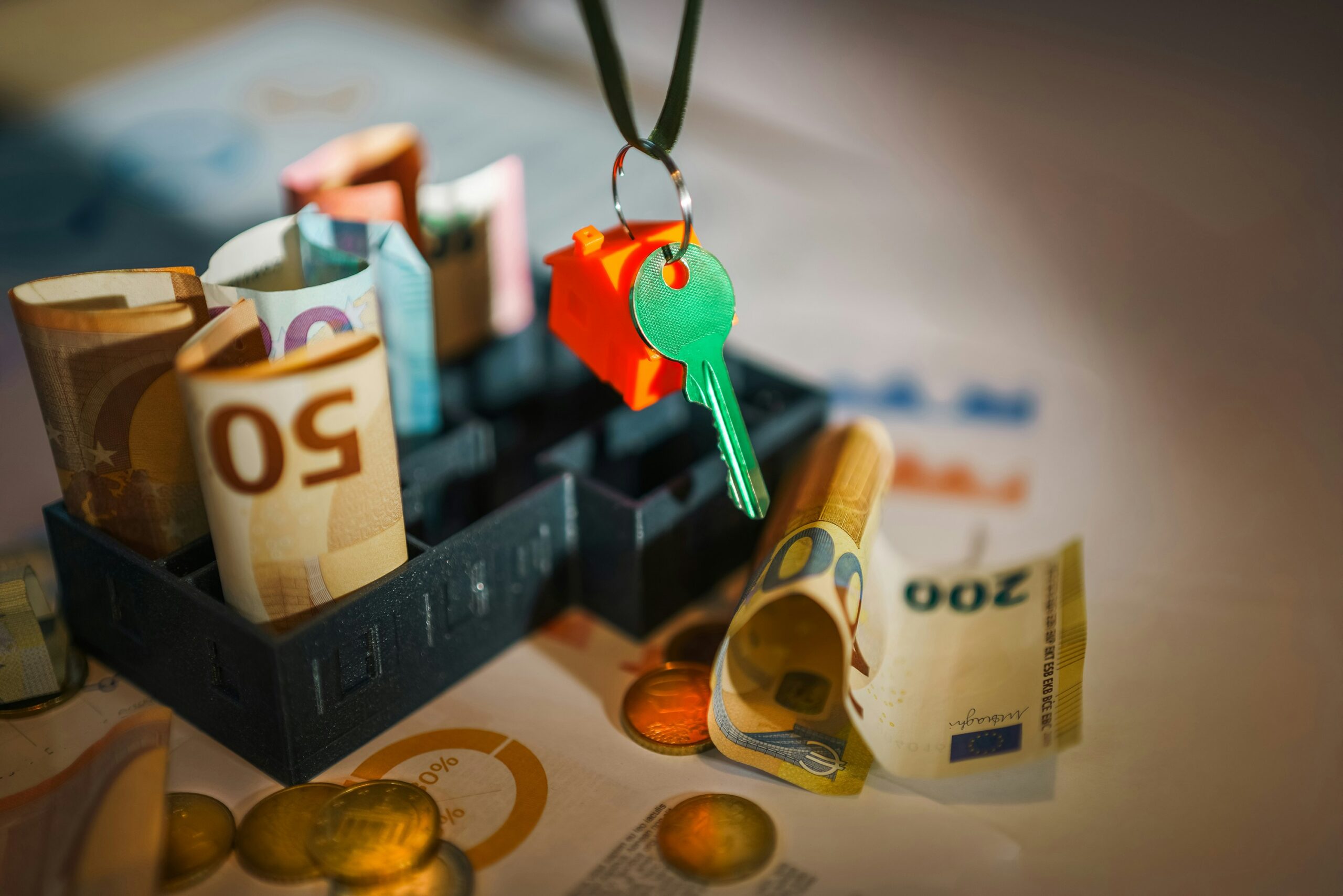 Schlüssel und Geld auf einem Schreibtisch – welche Versicherung ist wirklich nötig?