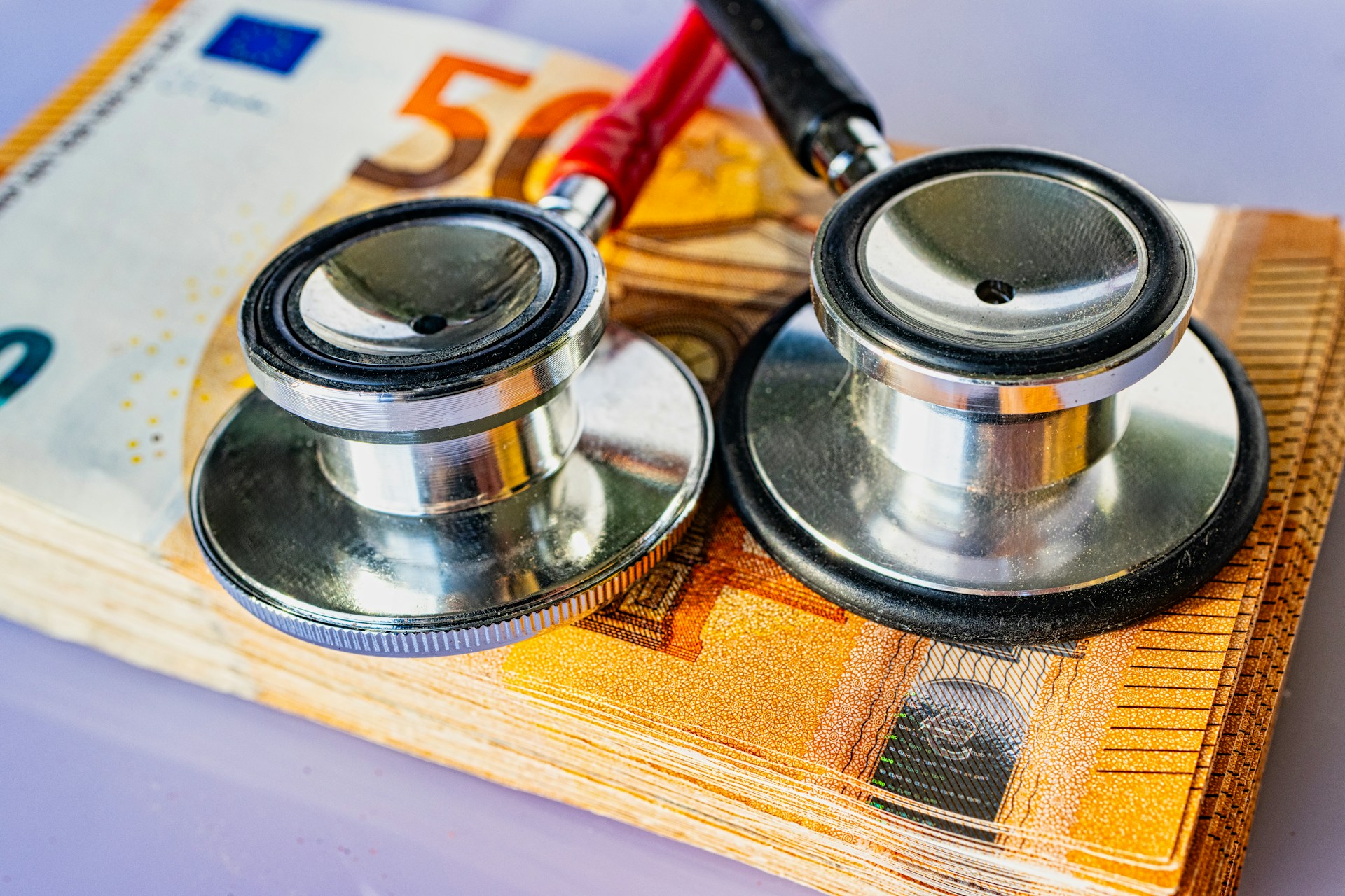 Stethoskop und Geldschein als Symbol für Krankenkassenvergleich und Sparpotenzial